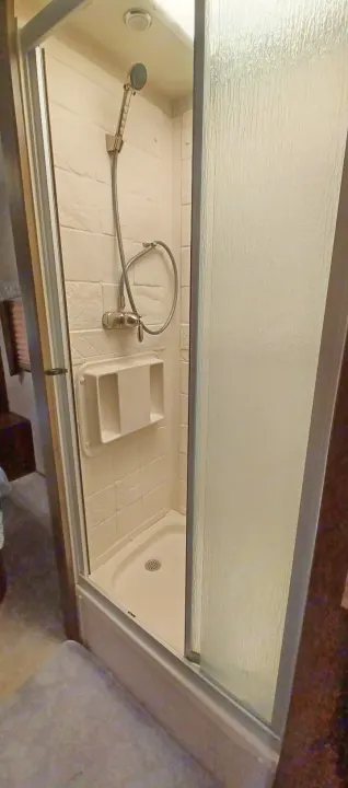 Compact shower in this RV rental. Enjoy travel comfort with a handheld shower and textured glass door.. Forest River Coachmen Freelander 2019