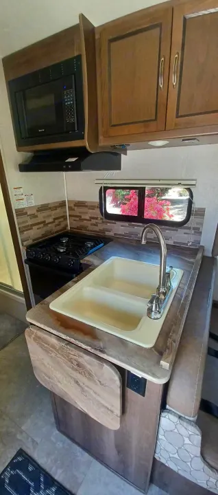This RV rental's kitchen features a microwave, gas stove, dual sink, and extendable countertop. Great for cooking on the road!. Forest River Coachmen Freelander 2019
