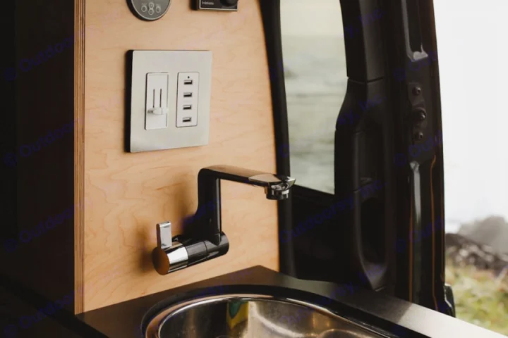 RV rental interior features a sleek black faucet, stainless sink, wood paneling, and USB/dimmer controls.. Mercedes-Benz metris 2022