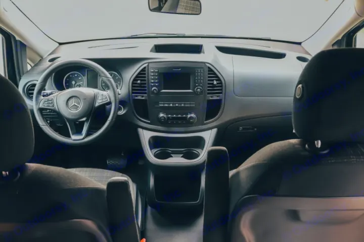 RV rental interior: Front view of Mercedes-Benz dashboard, steering wheel on left, center console with screen, and cup holders.. Mercedes-Benz metris 2022