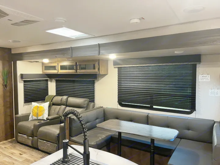 This RV rental features a comfortable living area with recliners, a dinette, and kitchen space.. Venture SPORTTREK 332VBH 2021