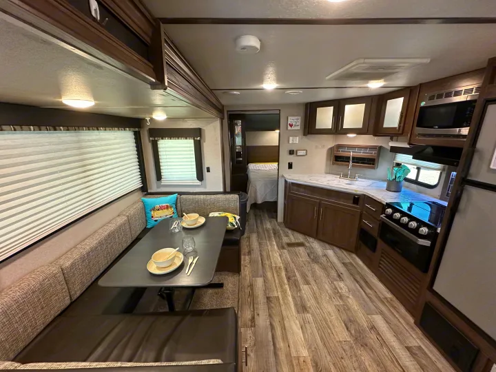 Spacious RV rental interior with full kitchen, comfortable dinette, and private bedroom area, perfect for your travels.. Keystone RV Hideout 2020
