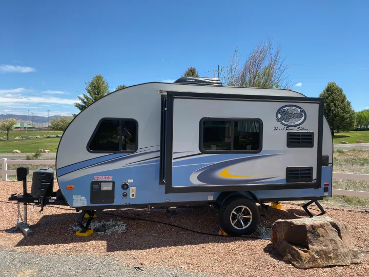 An R-Pod travel trailer, perfect for an RV rental, awaits adventure at a sunny campsite under a clear blue sky.. R-Pod Hood River Edition 2018