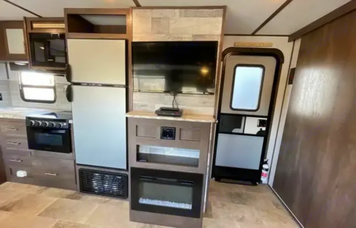 Step inside this RV rental: full kitchen with fridge, oven, microwave, plus TV and an electric fireplace.. Dutchmen Coleman Light 2020