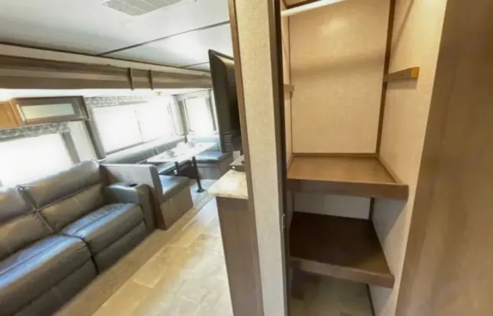 Inside this RV rental: a spacious living area with a comfortable sofa, dinette seating, and practical storage shelves.. Dutchmen Coleman Light 2020