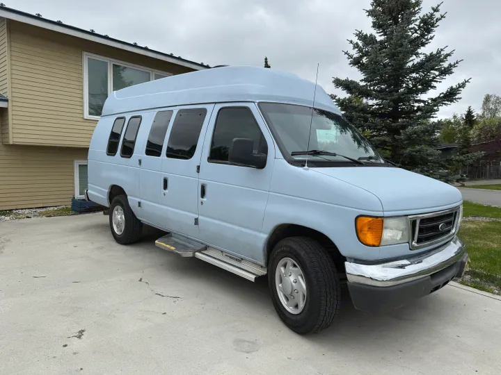 Light blue Ford Econoline high-top van, perfect for your next RV rental adventure, parked on concrete.. Ford E350 Super Duty 1-ton Camper Van 2006