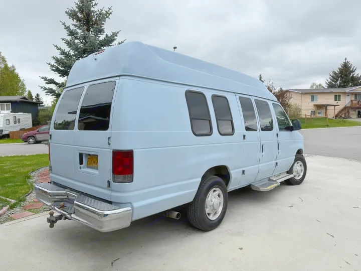 Light blue high-top Ford van, perfect for rv rental adventures. This versatile camper is ideal for exploring Alaska.. Ford E350 Super Duty 1-ton Camper Van 2006