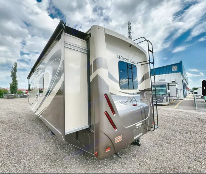 This large, modern Windsport motorhome, an ideal RV rental, shows its tan/brown exterior and extended side slide-out.. Thor Windsport 2019