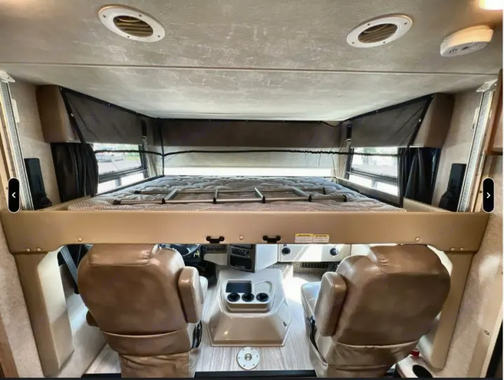 RV rental: Interior view of the front cabin, showcasing a spacious cab-over bunk bed above plush captain's chairs.. Thor Windsport 2019