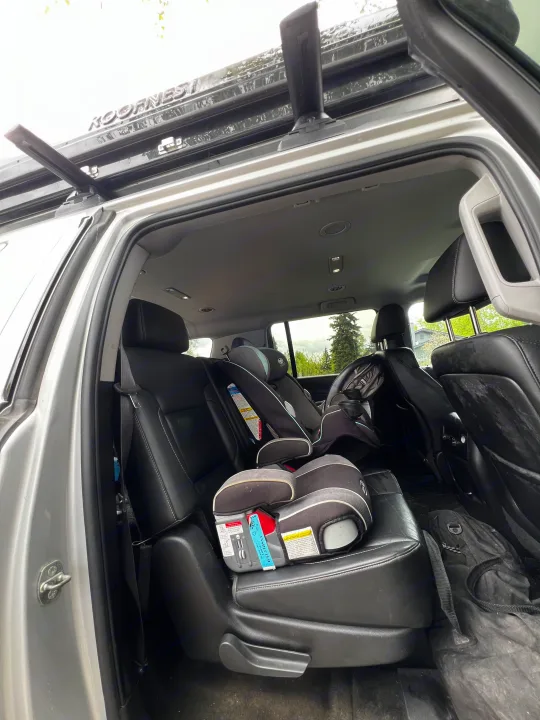 Spacious SUV interior with child car seats and Roofnest rack, ideal for family travel or an RV rental adventure.. Chevrolet Suburban 2015