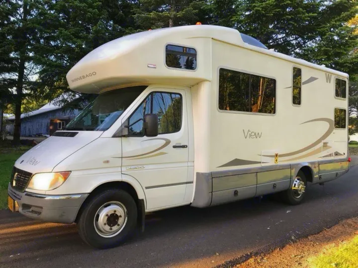 Spacious Winnebago View RV, a white and gray Class C model, ideal for your next RV rental adventure. Parked outdoors.. Winnebago View 2006