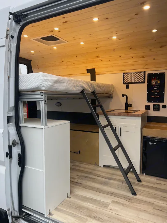 RV rental: Spacious camper van interior with raised bed, kitchen, and ample storage for comfortable mobile living.. Ram Promaster 1500 2020