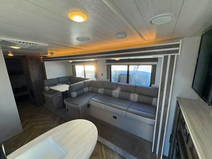 Spacious RV rental interior with a modern U-shaped dinette, kitchen counter, and comfortable living space.. Forest River Wildwood X-Lite 2022