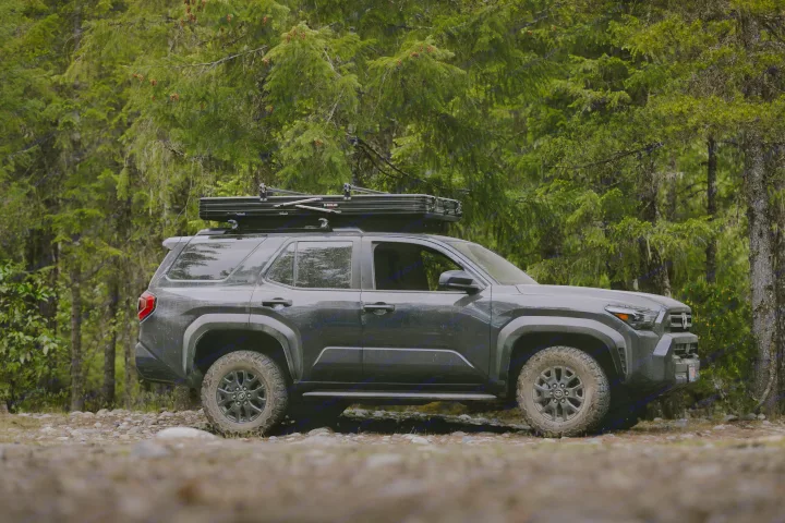 This dark SUV with roof-top tent is ready for your next RV rental adventure on a forest trail.. Toyota 4Runner 2025