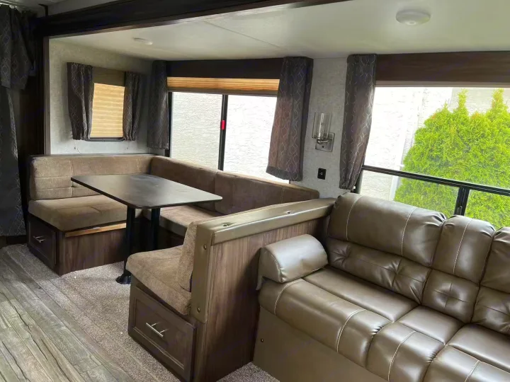 Spacious RV rental interior featuring a dinette, sofa, and large windows. Perfect for travel comfort.. Forest River Cherokee 2018