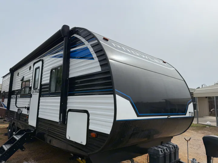 Prowler travel trailer rv rental with blue accents. This J&G Trailer Rentals unit is shown from the front-side angle.. Heartland RVs Prowler 2021