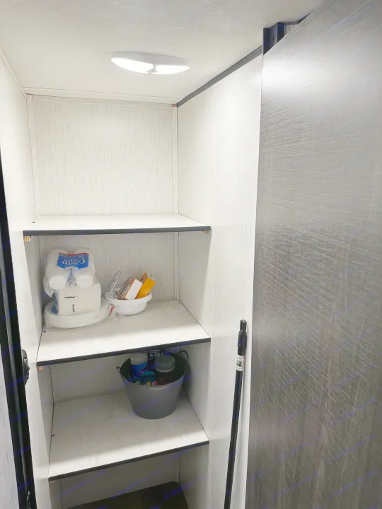 An organized RV rental interior: a bright storage closet with shelves holding paper goods and cleaning supplies.. 5sfeb3729me459252 31DB 2021