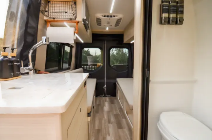 Explore this modern RV rental interior featuring a functional kitchen with sink, comfortable seating, and a private bathroom.. Cahaba Cahaba Class B 2021