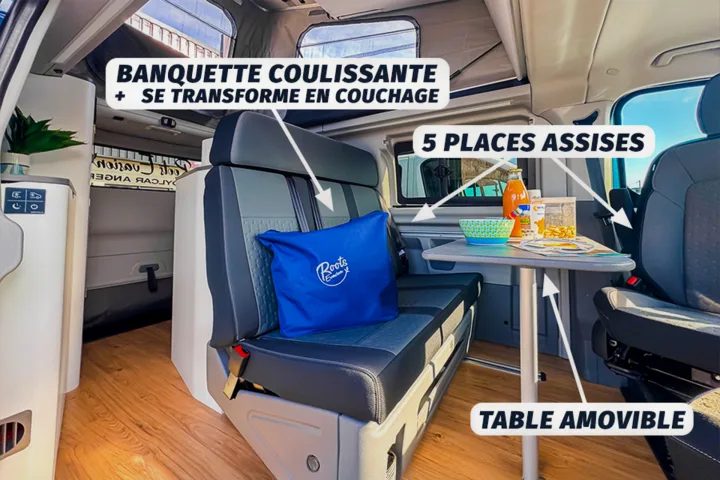 Inside this RV rental: multi-purpose bench transforms into a bed, with a removable table & seating for 5.. Ford Nugget 2025