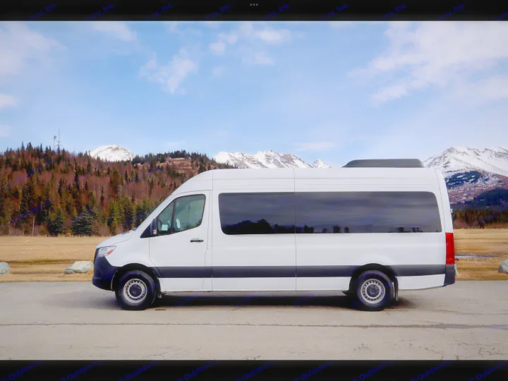 White RV rental van on a mountain road with snow-capped peaks & trees. Your adventure starts here!. Mercedes-Benz Sprinter 2025