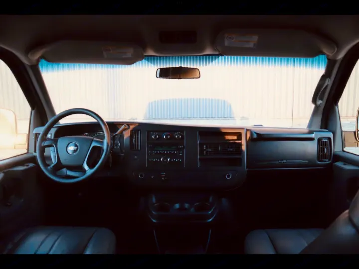 Interior view of a Chevrolet van, suitable for RV rental, showing the spacious driver's area, dashboard, and front seats.. Chevrolet Express 2008