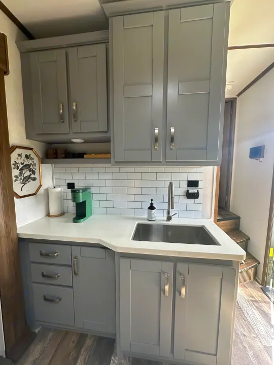 RV rental: A modern gray kitchen featuring shaker cabinets, white subway tile, a sink, and a green coffee maker.. Keystone RV Fuzion Toy Hauler 2021