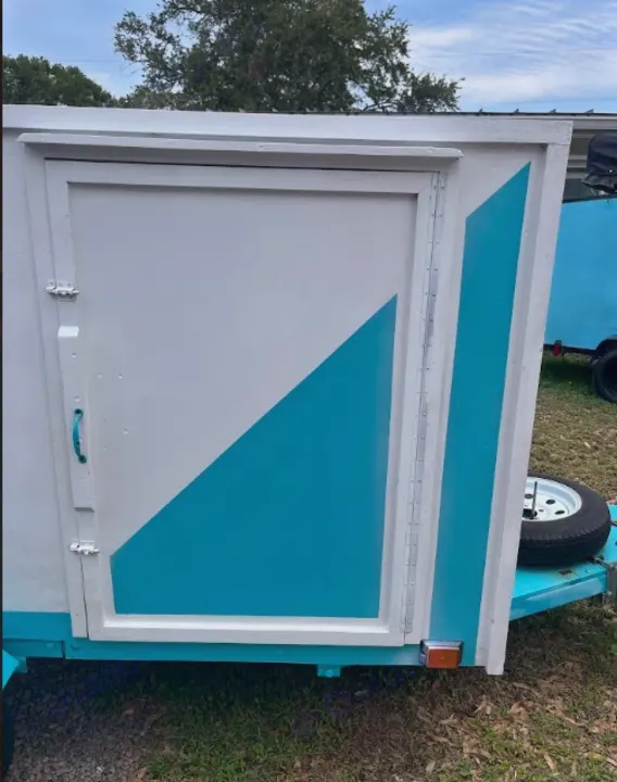 Side view of a small, custom-painted white & teal RV rental. This travel trailer is ready for your next adventure.. YNGQ Box 2017