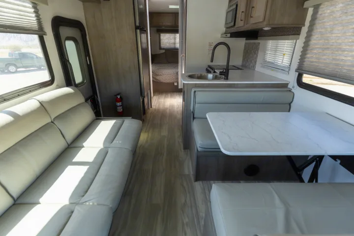 Discover the inviting interior of our rv rental, showcasing a well-equipped kitchen, cozy dinette, and sofa lounge.. Gulf Stream Conquest 2024