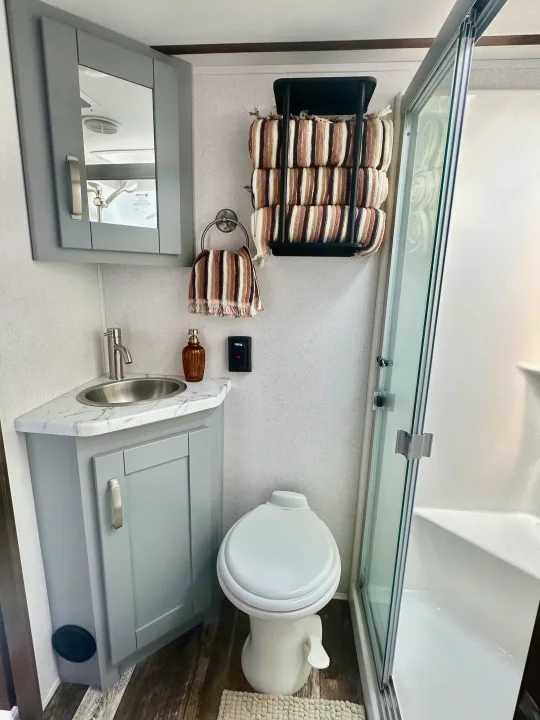 Clean, compact RV bathroom with a modern sink, toilet, and shower, ideal for your next RV rental adventure.. Keystone RV Fuzion Toy Hauler 2021