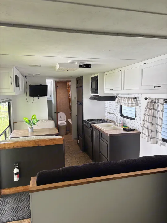 Explore this modern RV rental interior featuring a full kitchen, dinette, and bathroom. Perfect for travel adventures.. Forest River Cherokee Grey Wolf 2012