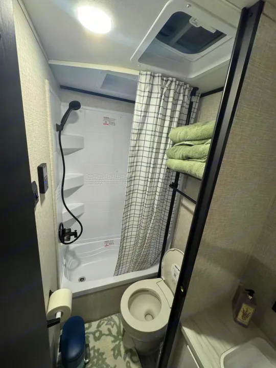This RV rental bathroom features a compact shower/tub combo, toilet, and vent for your journey.. Jayco JAY Flight SLX 261BHS 2025