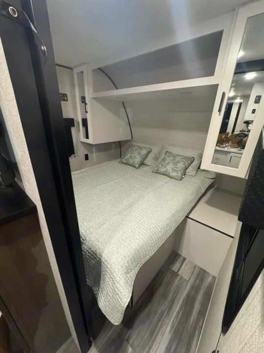 Cozy RV rental bedroom features a comfy bed, overhead storage, and a mirrored cabinet. Ideal for your next road trip.. Jayco JAY Flight SLX 261BHS 2025