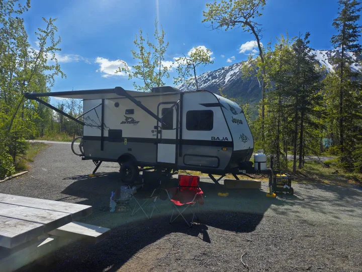 RV rental camper parked in a scenic mountain campsite with an awning, picnic table, & generator.. Jayco Jay Flight SLX Baja Edition 2022