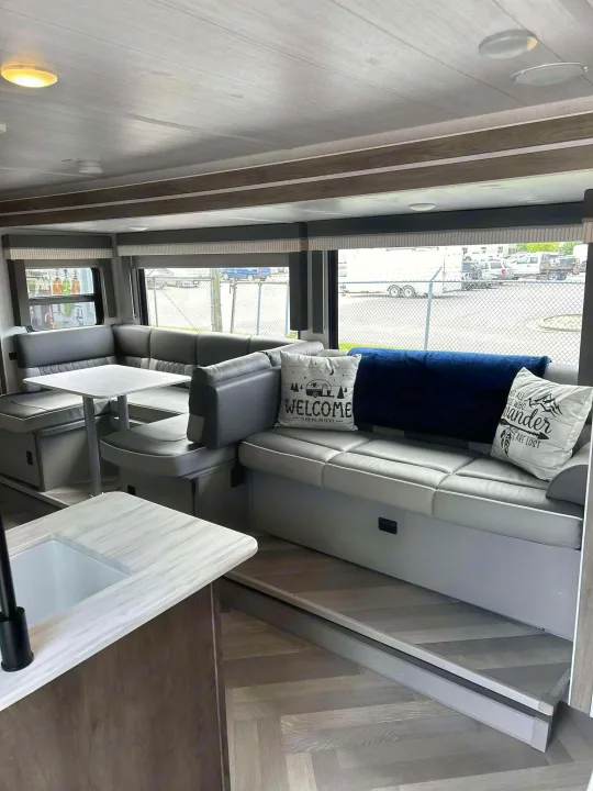 Inside a comfortable RV rental: modern dinette and lounge area with light wood accents and a bright interior.. Forest River Salem Cruise Lite 2022