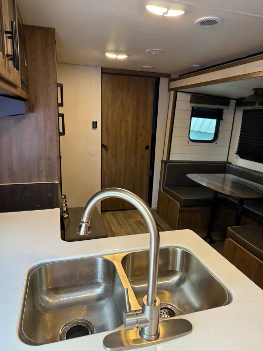 RV rental interior: A bright, modern kitchen with a dual sink and a cozy dinette area for dining and relaxation.. 5SFPB372XME475890 Pioneer 2021