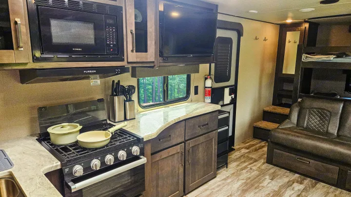 Modern RV rental interior with kitchen, living area, and bunk beds, perfect for family adventures.. Grand Design Transcend Xplor 2022
