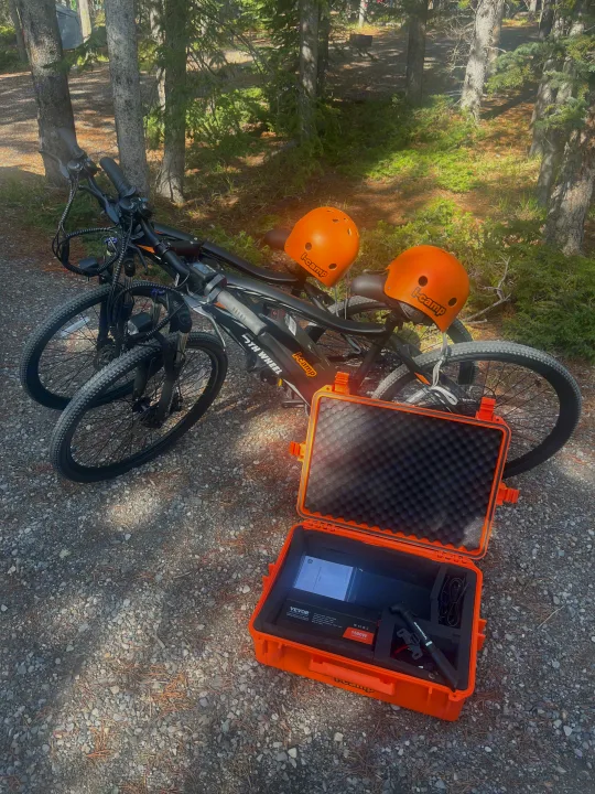 Two e-bikes, helmets, and a power station are ready for your RV rental adventure on this sunny outdoor trail.. Sunset Sunray 109 sport 2025
