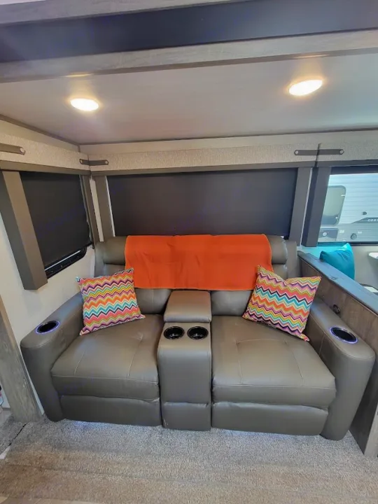 Cozy RV rental interior with gray theater seating, cup holders, and colorful pillows, perfect for relaxing on your trip.. Forest River Salem Hemisphere 2021