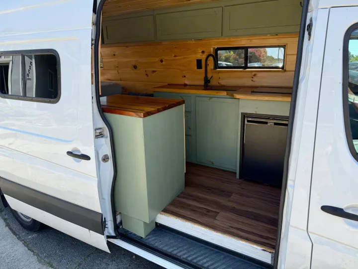 White camper van conversion interior: wood, green cabinets, sink, fridge. Great for RV rental!. Dodge Sprinter 3500 2007