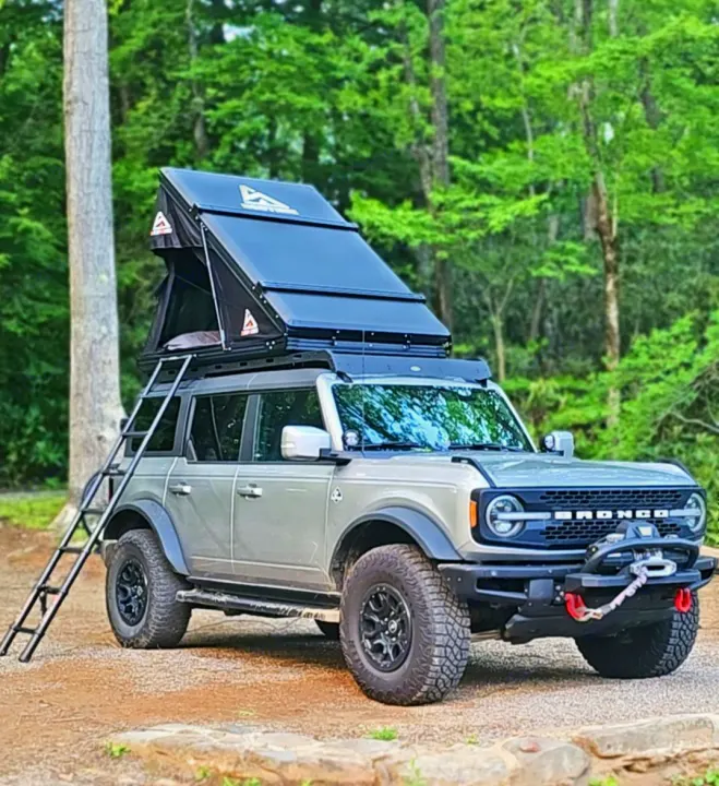 Adventure-ready Ford Bronco with a deployed rooftop tent & ladder, perfect for overlanding. A unique RV rental option!. Ford Bronco Outer Banks 2022