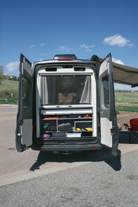 Rear view of an RV rental camper van, doors open to reveal custom organized storage. Ready for your next outdoor adventure.. Forest River Coachmen Crossfit 2018