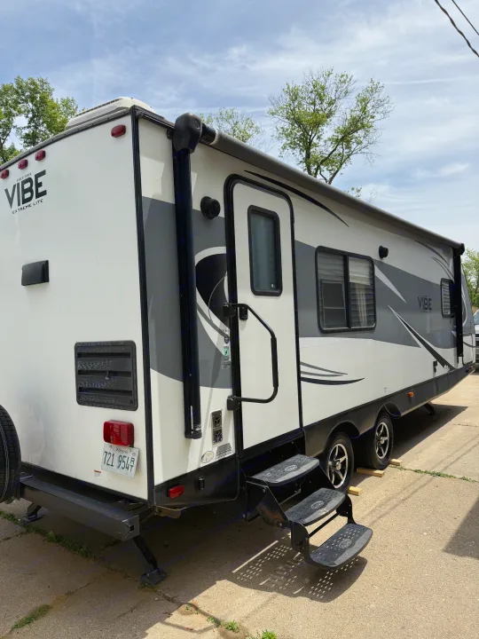 White & grey Forest River Vibe travel trailer, ideal for an rv rental. Features extended steps, rolled awning, & rear jacks.. Forest River Vibe Extreme Lite 2017
