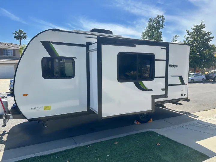 New white travel trailer with slide-out extended, showcasing a spacious RV rental for outdoor adventures.. Autumn Ridge 188BHS 2025