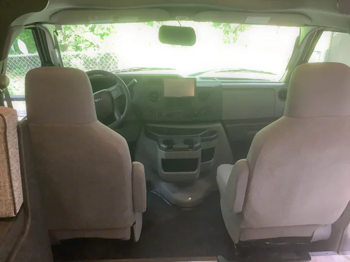 RV rental interior: A bright view of the front cabin, showing driver & passenger seats, Ford steering wheel, and dashboard.. Forest River Solera 27 DSE 2023