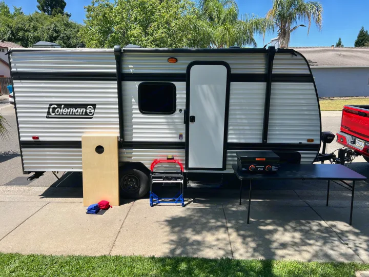 Coleman RV rental set up with a Blackstone griddle and cornhole game, ready for outdoor fun.. Coleman Lantern 17B 2025