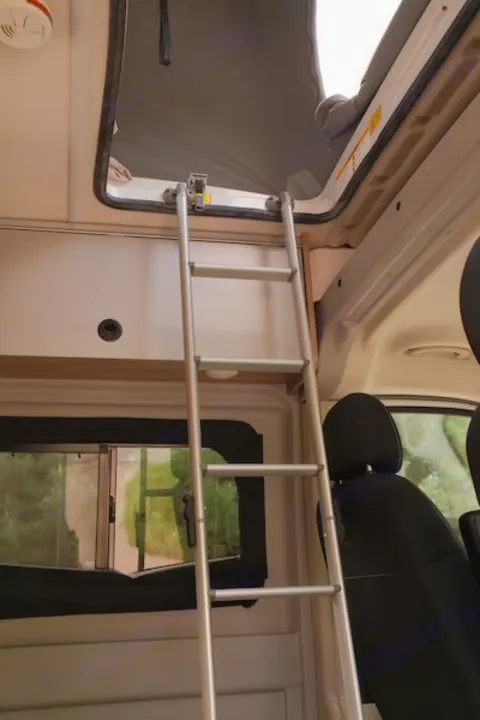 Inside RV rental: ladder accesses elevated sleeping area. Includes smoke detector and window.. Winnebago Solis 2022