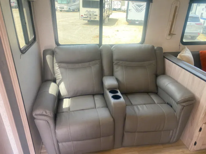 Relax in this RV rental's grey theater seating, featuring two recliners and a console with cup holders.. Coachmen Northern  Spirit Ultra Lite 2024