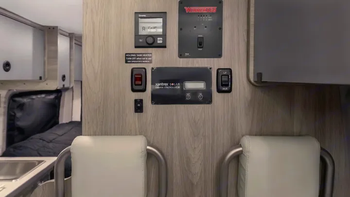RV rental: Detailed view of the RV's control panel wall, featuring solar, water, heat, and LP gas systems.. Winnebago Solis 2021