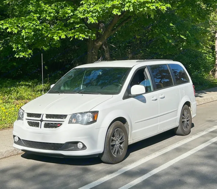 A white Dodge Grand Caravan minivan, not an rv rental, parked on a sunny day with green foliage behind.. Dodge Dodge Grand Caravan GT 2017 2017