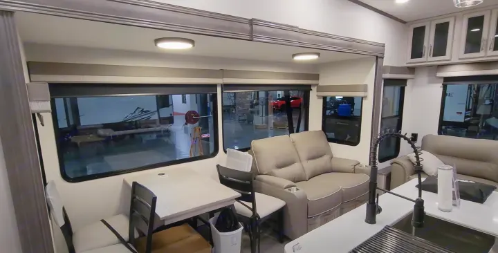View inside an RV rental showing a contemporary living space with a kitchen sink, dining table, and cozy sofa.. Forest River 3370RLS 2024